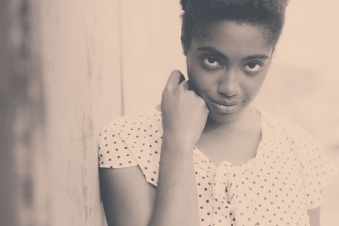 Smiling African American woman leaning on wall