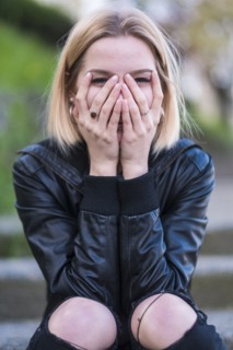Laughing Caucasian woman covering face with hands