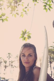 Portrait of Caucasian woman holding surfboard