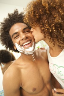 Girlfriend kissing boyfriend's shaving cream-covered face