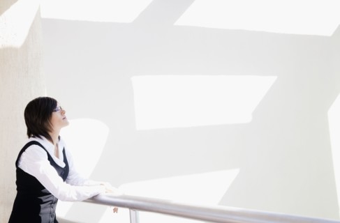 Hispanic businesswoman standing in office lobby