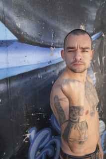 Bare chested Hispanic man with tattoos