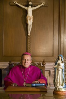 Hispanic bishop sitting with bible