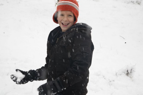 Hispanic boy throwing snowballs