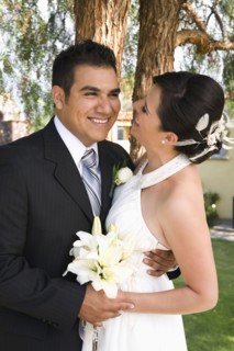 Hispanic bride and groom hugging