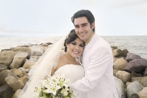 Hispanic bride and groom hugging