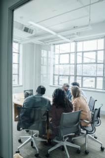Business people on video conference behind window