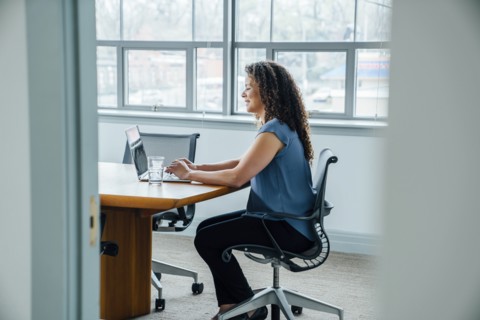 Mixed race businesswoman using laptop