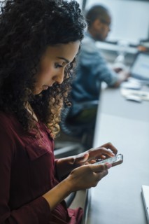 Businesswoman using cell phone in office