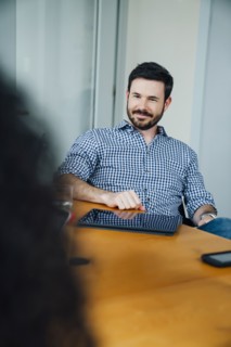 Smiling Caucasian businessman listening in meeting