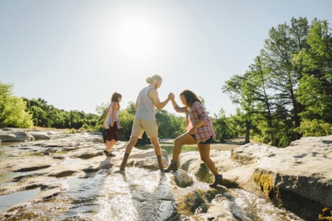 Man helping woman crossing river