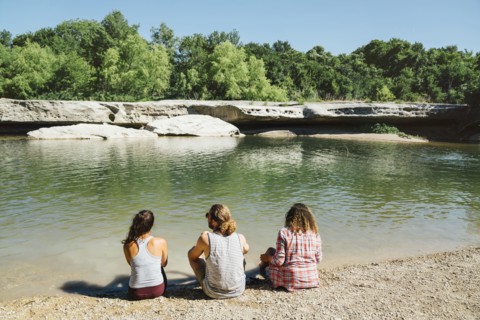 Friends sitting near river