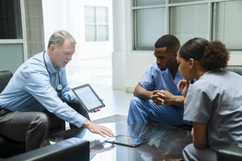 Doctor and nurses discussing digital tablet