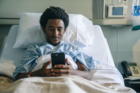 Blackboard texting on cell phone in hospital bed