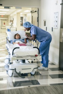 Nurse talking to girl in hospital gurney