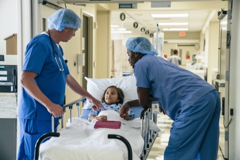 Nurses talking to girl in hospital gurney