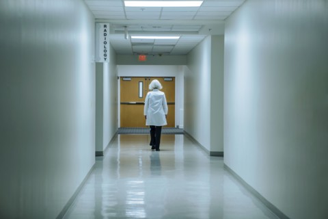 Caucasian doctor walking in hospital