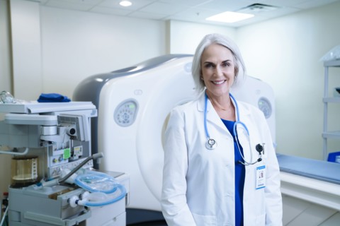 Portrait of smiling Caucasian doctor near scanner
