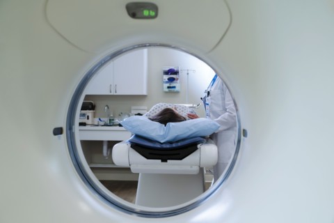 Caucasian doctor comforting patient near scanner