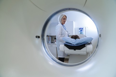 Caucasian doctor talking to patient near scanner