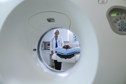 Caucasian doctor comforting patient near scanner