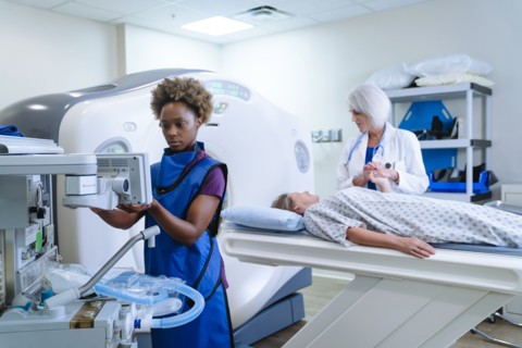 Technician preparing scanner for doctor comforting patient