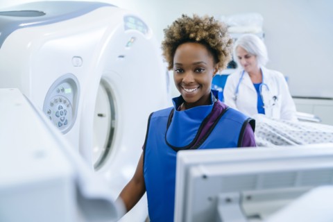 Smiling technician preparing scanner for doctor comforting patient