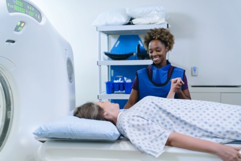 Technician holding hand of patient at scanner