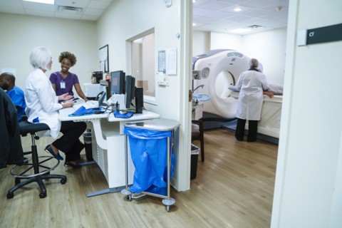Doctor and technician talking near scanner