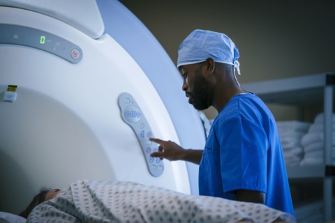 Technician talking to patient at scanner