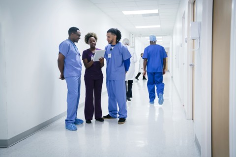 Nurses discussing digital tablet in hospital