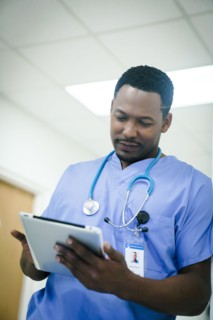 Black nurse using digital tablet in hospital