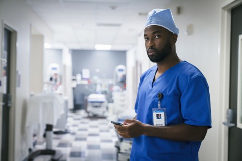 Portrait of black nurse texting on cell phone