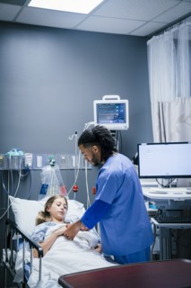 Nurse holding hand of patient in hospital