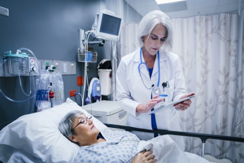 Doctor with digital tablet talking to patient