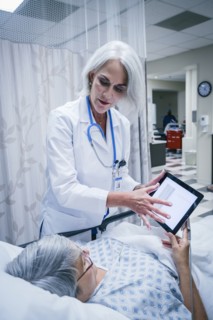 Doctor showing digital tablet to patient