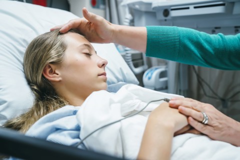 Caucasian doctor comforting patient in hospital bed