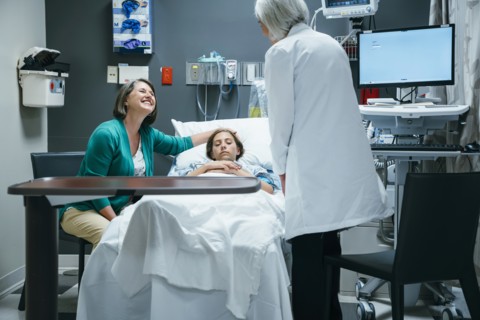 Caucasian doctor talking to mother and daughter in hospital