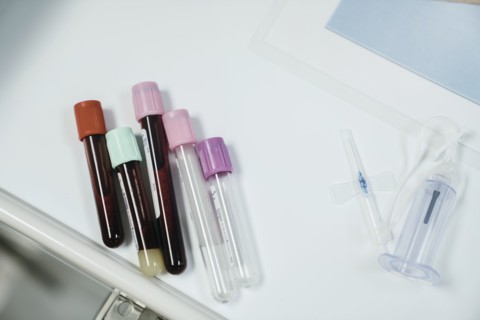 Test tubes with caps on table near syringe