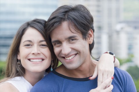 Hispanic couple hugging outdoors