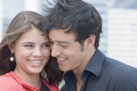 Hispanic couple hugging outdoors