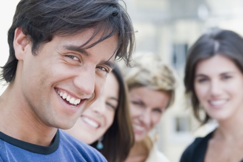 Hispanic man smiling with friends in background