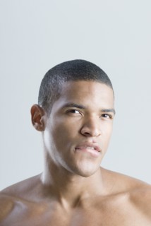 Bare-chested African man biting lip