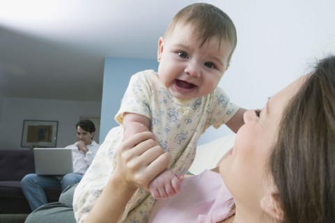 Hispanic mother playing with baby