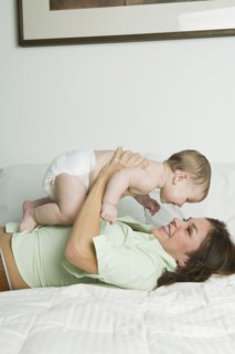 Hispanic mother playing with baby