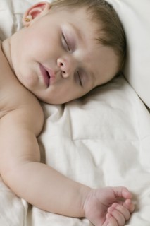 Hispanic baby sleeping on bed