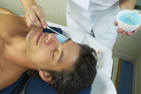 Hispanic man receiving spa facial treatment