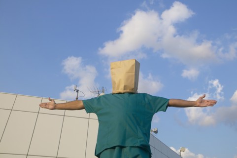 Hispanic male doctor wearing bag over head