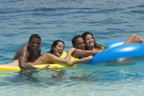 Multi-ethnic friends on floats in water
