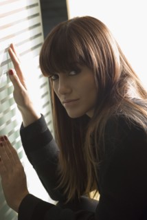 Young woman with hands on glass door